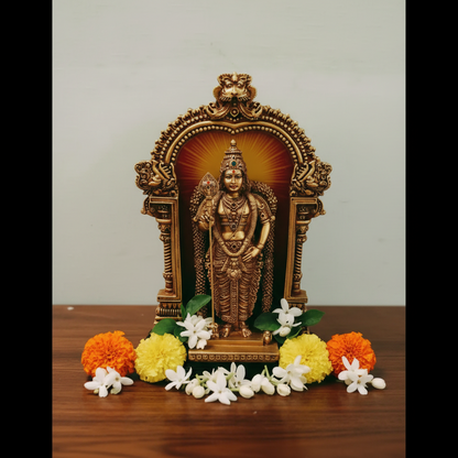 Decorative statue of a deity with flowers on a wooden surface