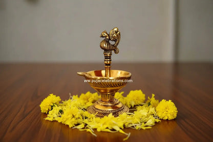 Close up of intricate Annapakshi bird carving on diya