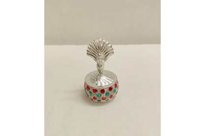Silver peacock kumkum box placed as a decorative element in a home pooja mandir