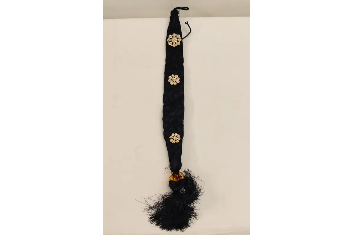 Black feathered hair accessory with gold brooches on a white background