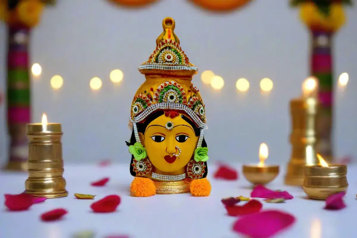 A decorative yellow idol of a Hindu goddess, adorned with a detailed golden crown and jewellery - Puja celebrations