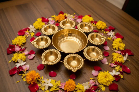 Decorative arrangement of gold bowls and flowers on a wooden surface