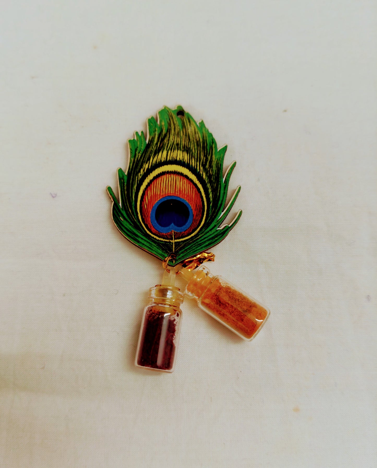 Pin with peacock feather and small bottles on a white background