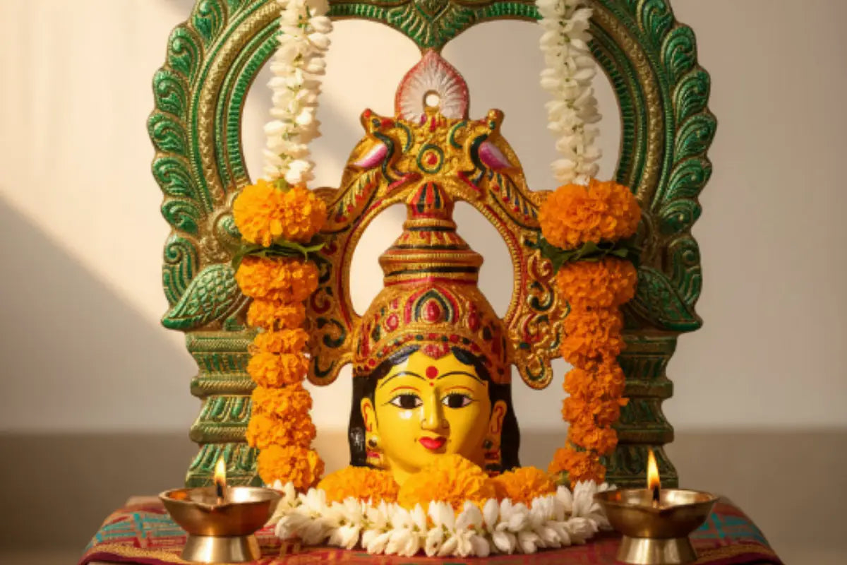 Decorated metal Amman Devi face with peacock Prabhavali mounted securely on a copper puja kalash pot
