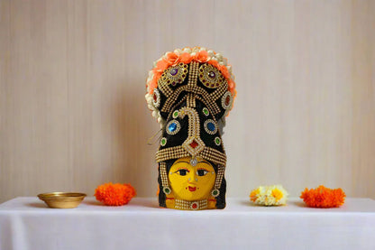 andcrafted Varalakshmi Amman face with pre-decorated hair bun attached to a festive puja kalasham setup