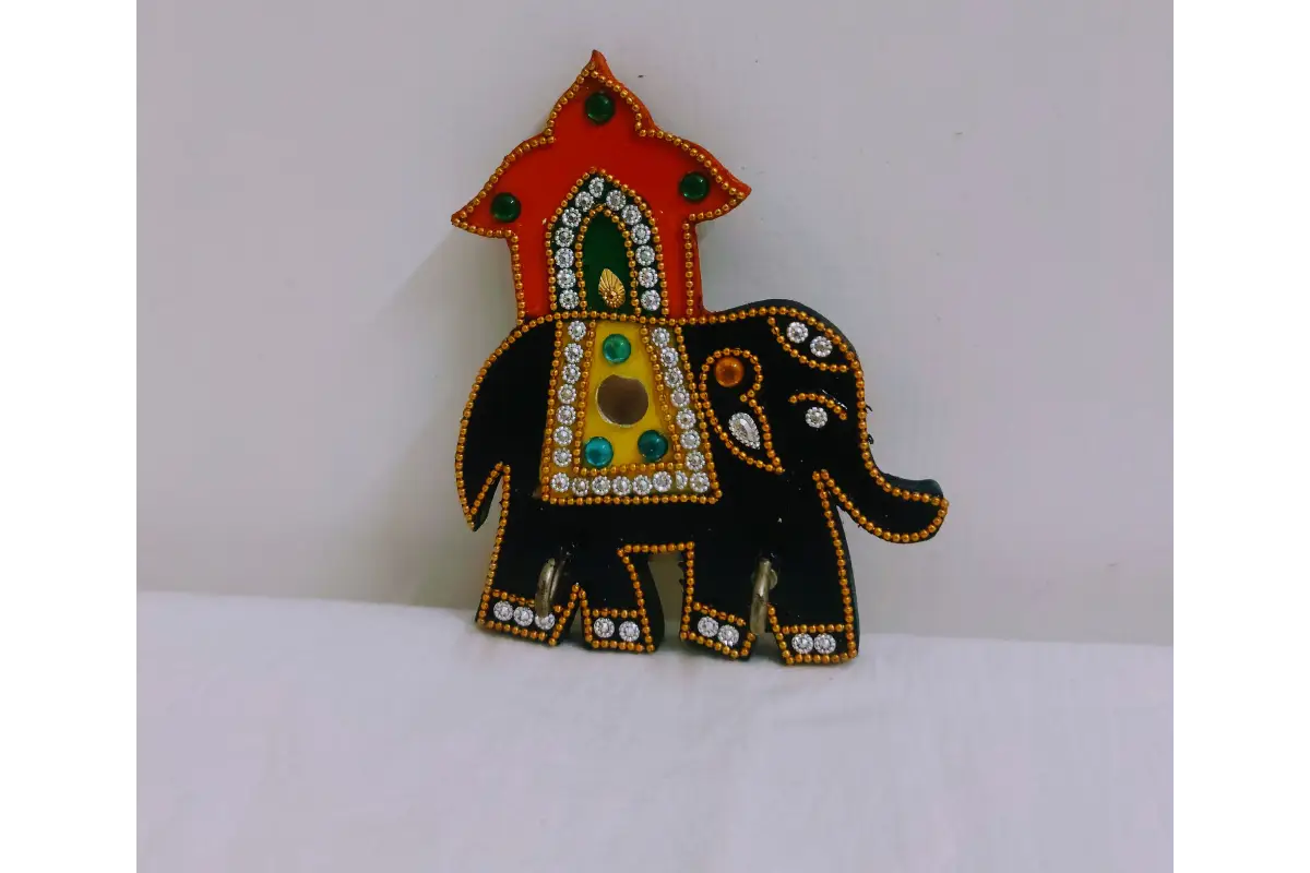 Detail view of sturdy metal key hooks mounted on wooden elephant keyholder