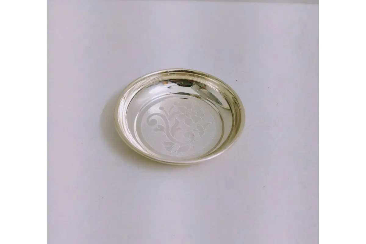 Close-up view of intricate floral embossing and mirror polish on German silver plate