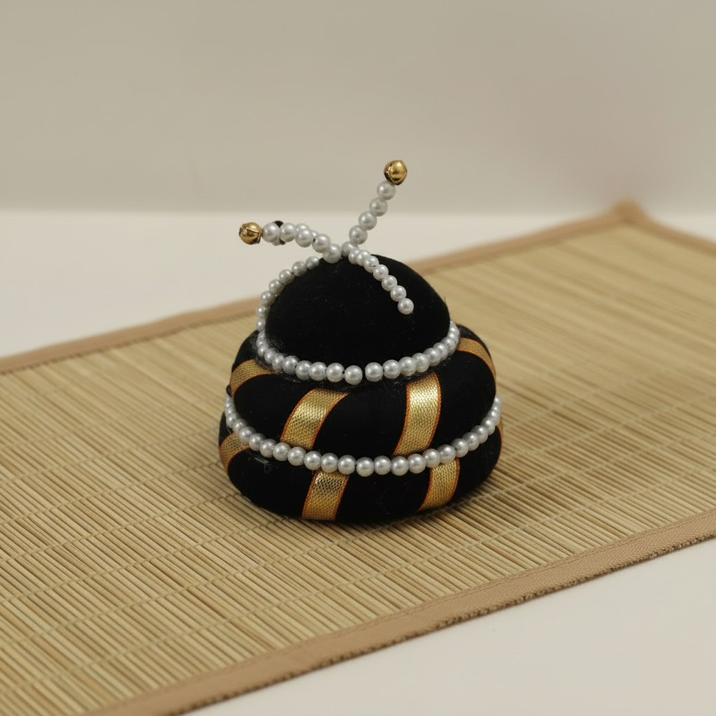 Decorative item resembling a bee with black, gold, and white colors on a textured surface.