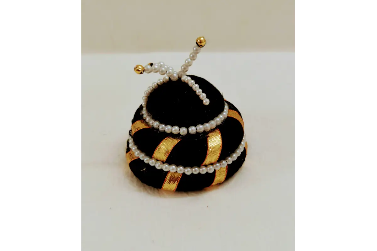 Decorative item resembling a beehive with a bee on top, featuring black, gold, and white colors.
