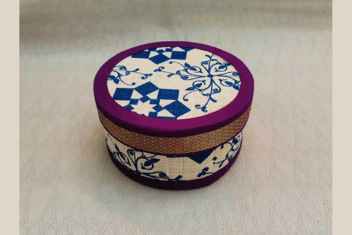Sustainable jute storage box with a vibrant orange zari-style trim.