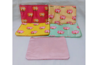 Close-up view of vibrant pink lotus print on soft yellow satin fabric pouch