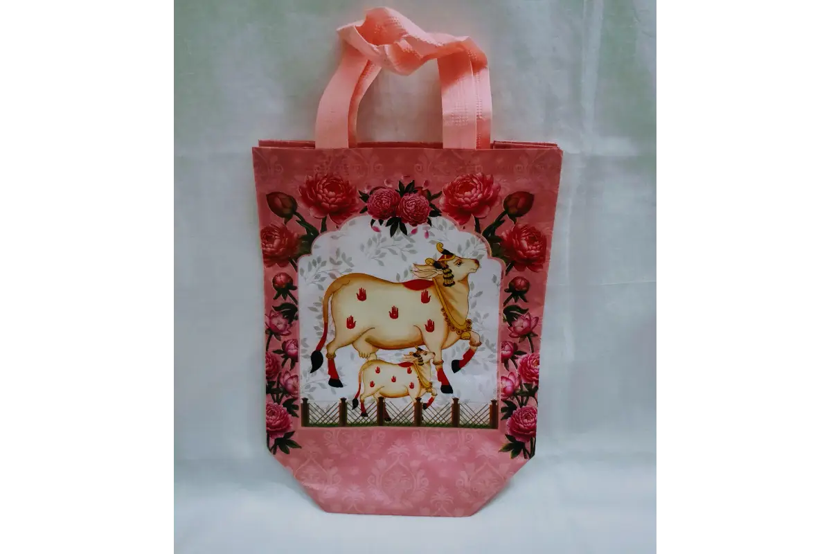 Close-up view of vibrant Pichwai lotus and cow artwork printed on durable return gift bag
