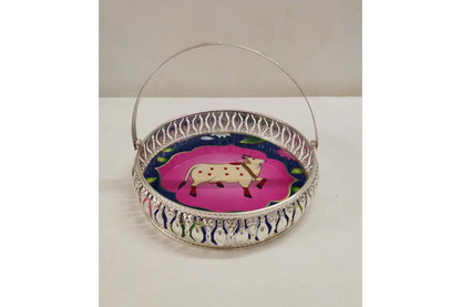 Decorative metal basket with a cow design on a white background