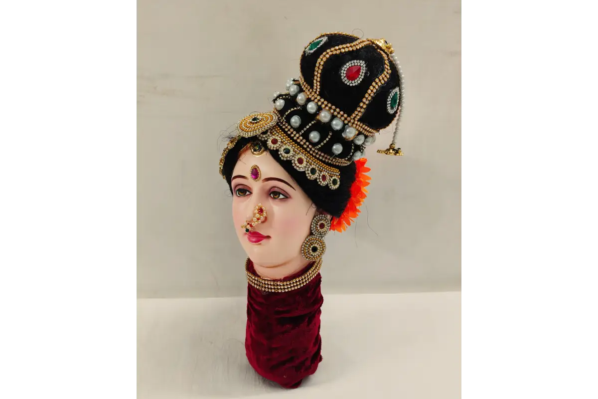 Traditional headpiece with jewelry on a mannequin head against a neutral background