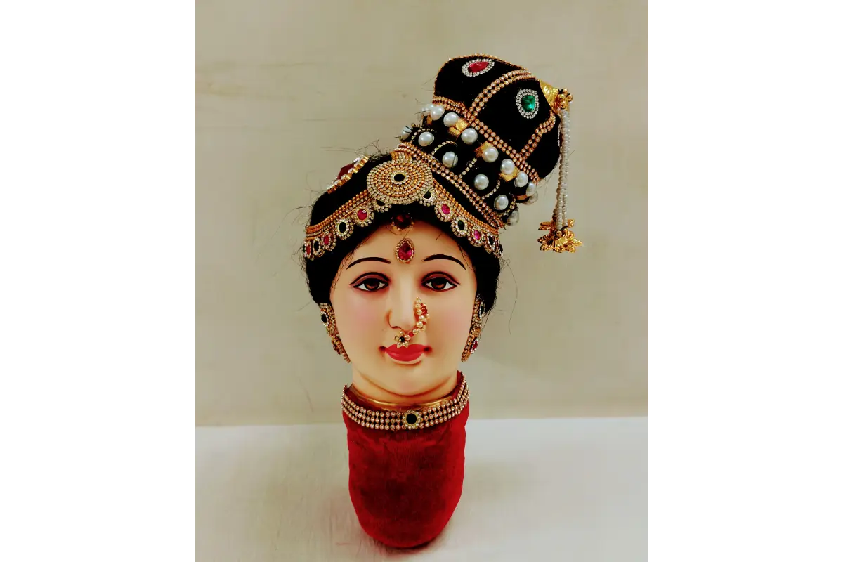 Decorative head with jewelry and a red base on a white background