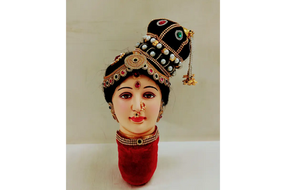 Decorative head with jewelry and a red base on a white background