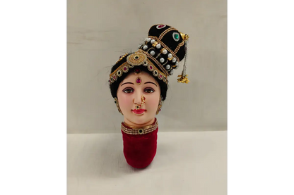 Traditional Indian doll head with jewelry and a headdress on a white background