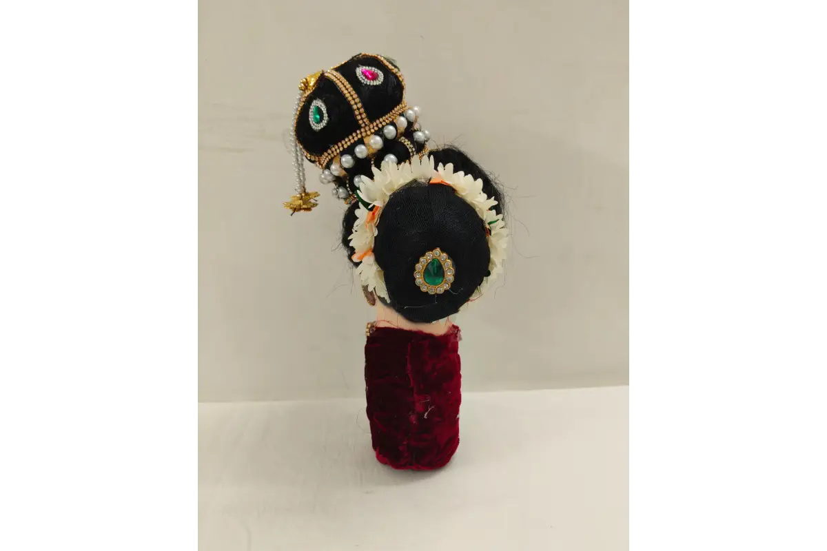 Decorative headpiece with black base, gold accents, and red fabric on a white background