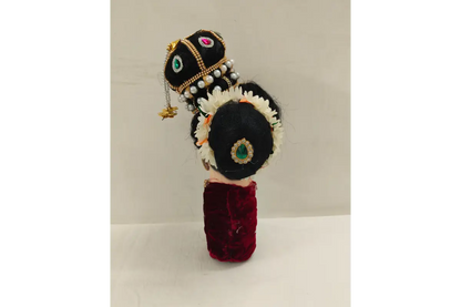 Decorative headpiece with black base, gold accents, and red fabric on a white background