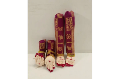 Decorative items resembling feet and hands with intricate designs on a plain background