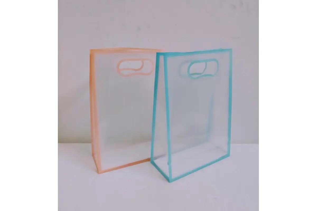 Close-up view of reinforced stitching and durable handle attachment on clear PVC gift bag