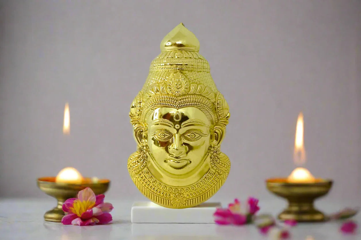 Metal Ammavaru Gowri face mounted securely on a sacred coconut and brass kalash setup in a home temple- Puja Celebrations