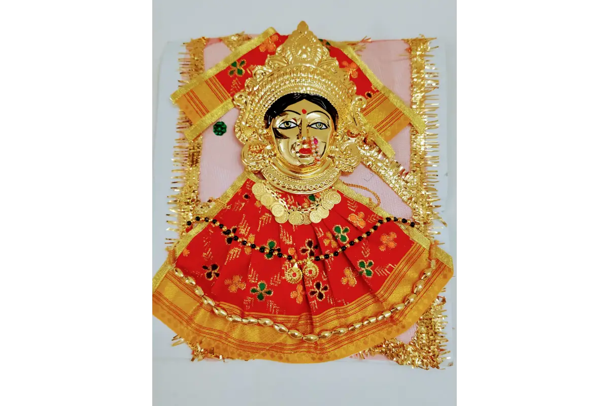 Decorative item with a face design in a gold and red frame on a white background