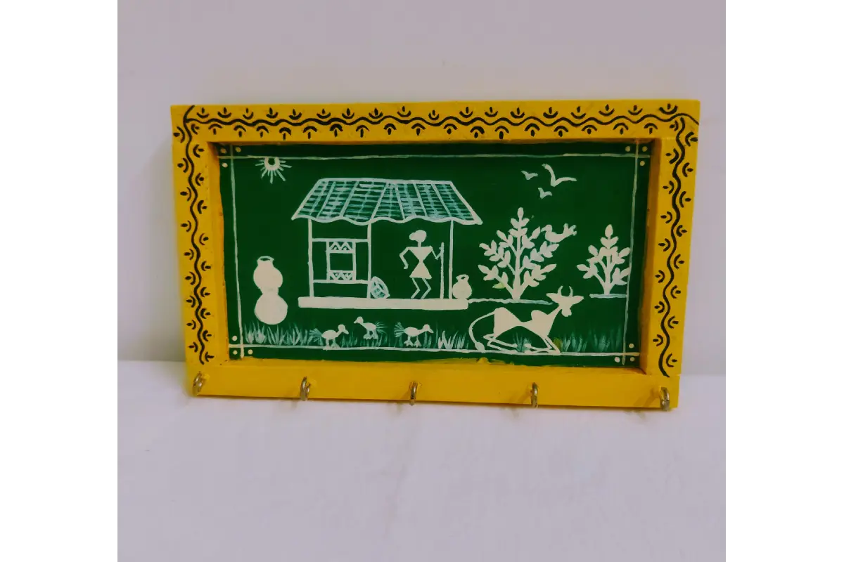 Close-up view of traditional white Warli tribal figure artwork on brown wooden keyholder