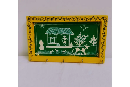 Close-up view of traditional white Warli tribal figure artwork on brown wooden keyholder