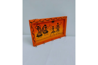 Detail view of sturdy metal key hooks mounted on wooden Warli painting key holder