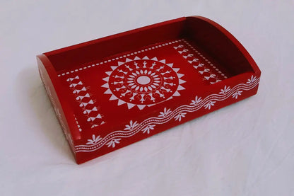Close-up shot of detailed white Warli art print on dark brown wooden serving tray