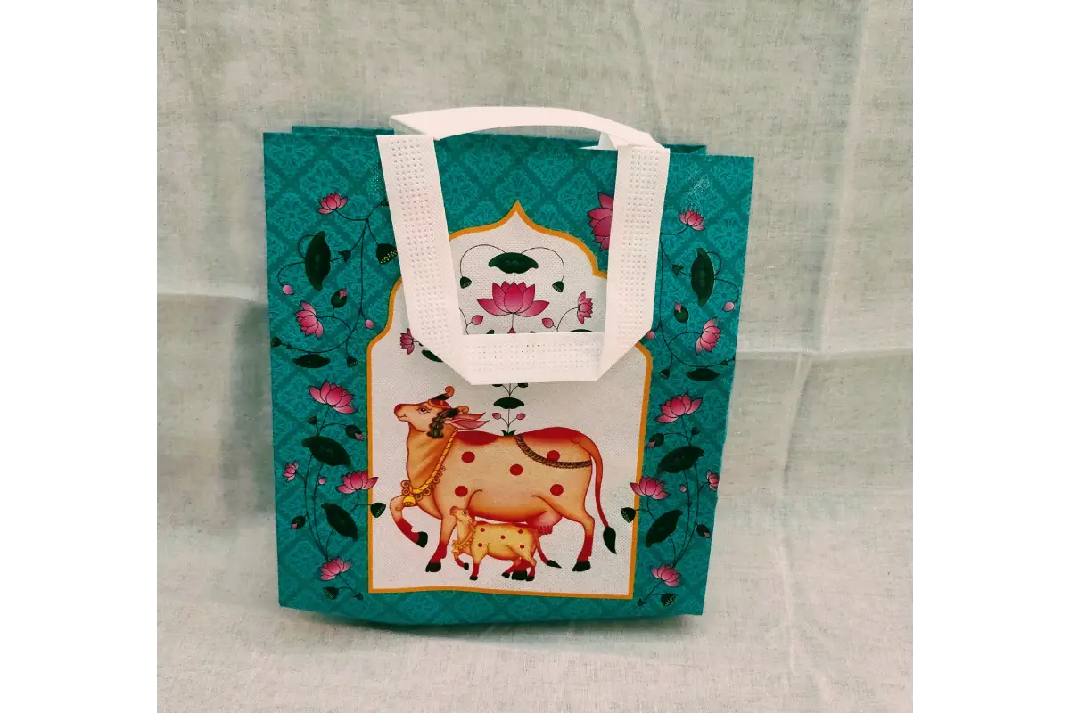 Bulk stacks of Pichwai print Thamboolam bags ready for wholesale return gift orders by Puja Celebrations