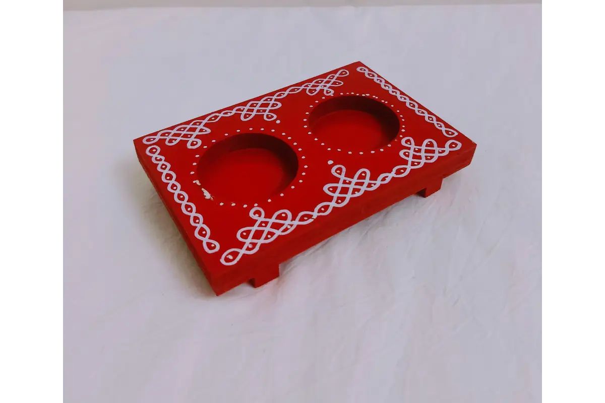 Wooden diya holder arranged with traditional kolam prints and designs