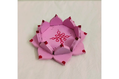 Wooden lotus diya stand placed at the center of a colorful flower rangoli for Diwali decor